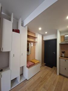 a small kitchen with white cabinets and a door at Le "BonLieu" - Annecy Lac & Centre Ville in Annecy