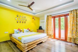 a yellow bedroom with a bed and a window at Signature Grande with swimming pool pondicherry in Pondicherry +51 photos