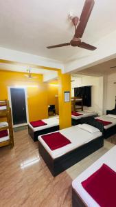 a room with four beds and a ceiling fan at Hotel GANANJAYA in Gokarna