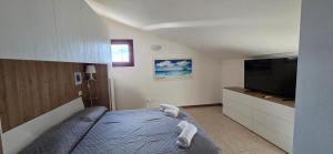 a bedroom with a bed and a flat screen tv at Mars' apartment in Cavalcaselle