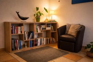 a room with a book shelf with books and a chair at Chambre d'hotes Bessiard in Laparrouquial