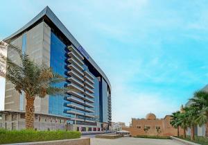 a tall building with a palm tree in front of it at Copthorne Hotel Dubai in Dubai