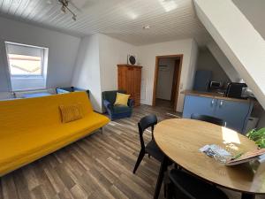 a living room with a yellow couch and a table at See You 2 in Germersheim