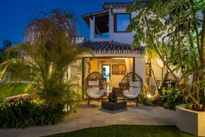a patio of a house with two chairs and trees at Villa Turrion in Marbella