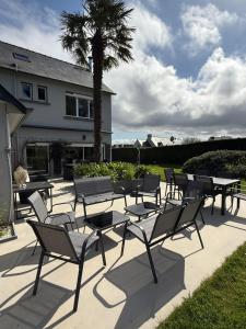 a group of tables and chairs in front of a house at Villa Bretagne 5 chambres doubles 3 SDB in Plérin