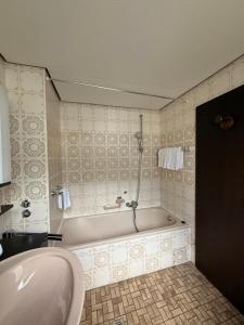 a bathroom with a bath tub and a sink at Hotel Stadt Lübeck in Timmendorfer Strand +23 photos