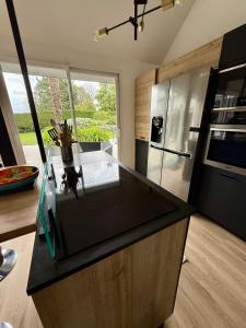 a kitchen with a counter top and a refrigerator at Villa Bretagne 5 chambres doubles 3 SDB in Plérin