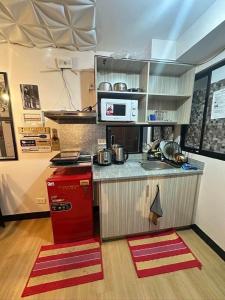 a kitchen with a counter and a red refrigerator at Retro Themed Condominium Staycation in Marilao