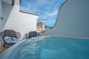 ein Schwimmbecken mitten in einem Gebäude mit Stühlen in der Unterkunft Boutique Hotel Imperialart in Meran