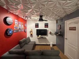 a living room with a couch and a flat screen tv at Retro Themed Condominium Staycation in Marilao
