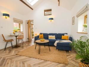 a living room with a blue couch and a table at The Blacksmiths Shop in Bromyard