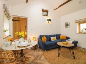 a living room with a blue couch and a table at The Blacksmiths Shop in Bromyard +24 photos