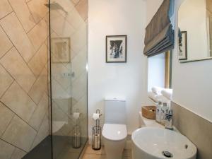 a bathroom with a toilet and a glass shower at The Blacksmiths Shop in Bromyard