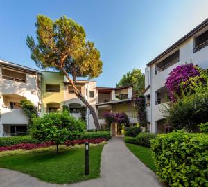 an apartment building with a walkway and flowers at Paloma Sencia in Belek