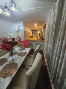 a living room with a dining table and a kitchen at Peaceful Corner Stay in Durban