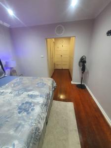 a bedroom with a bed and a hallway with a door at Peaceful Corner Stay in Durban