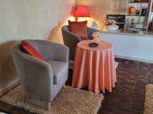 a living room with two chairs and a table at La Belle des Champs in Saint-Andelain +11 photos