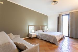 a bedroom with a bed and a couch at Podere San Michele Cantina con Camere in San Vincenzo