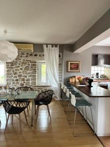 a kitchen with a table and chairs and a stone wall at Villa Palmyra in Nydri