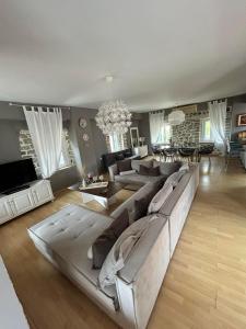 a large living room with a large couch and a dining room at Villa Palmyra in Nydri