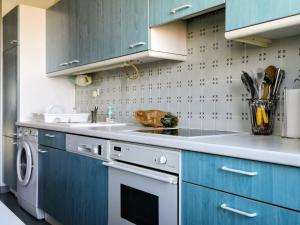 a kitchen with blue cabinets and a sink at Charming 96m2 fantastic view in Tourcoing