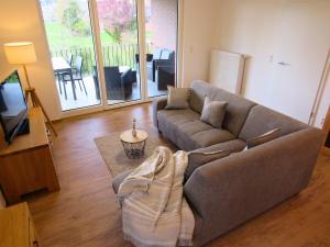 a living room with a couch and a television at Landhaus de Bel in Hergenrath