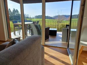 a living room with a couch and a view of a patio at Landhaus de Bel in Hergenrath