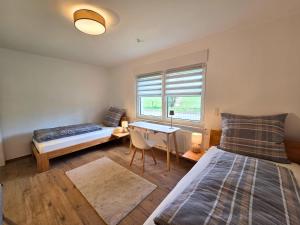 a bedroom with a bed and a desk and a window at Landhaus de Bel in Hergenrath