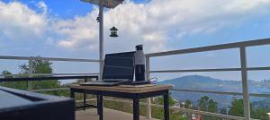 a laptop computer sitting on a table on a balcony at Smiley Homestay Family-Friendly 3BR in Kodaikānāl
