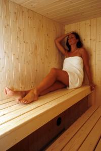 a woman is sitting in a sauna at Boutique Hotel Kaštel, Wellness & SPA, Pet Friendly in Motovun