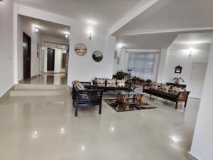 a living room with couches and a table in a room at Lashisha in Shillong +27 photos