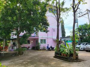 a pink building with trees in front of it at พีพีเพลส in Ban Lak Roi