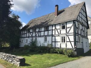 a white house with a black and white roof at Knochenhaus in Schmallenberg