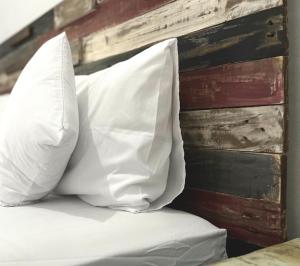 two white pillows sitting on a bed against a wall at Surabaya Vibes Hostel in Surabaya