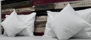 a group of white pillows sitting on a bed at Surabaya Vibes Hostel in Surabaya