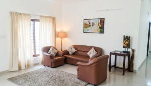 a living room with a couch and a table at Starlight Hotels OMR Thoraipakkam in Chennai
