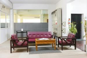 a living room with a purple couch and two chairs at Starlight Hotels OMR Thoraipakkam in Chennai