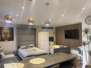 a room with two beds and a table and a tv at Family cottage in Epsom +4 photos