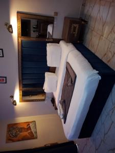 a bedroom with a bed with white sheets and a mirror at Mar'maris Residence Hotel in Owerri