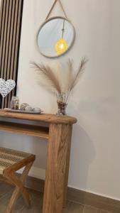 a table with a mirror and a vase with feathers at Seaview Apartments in Anavyssos