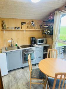 a kitchen with a table and a sink and a stove at Vestra Fíflholt Cabin 4 in Hvolsvöllur
