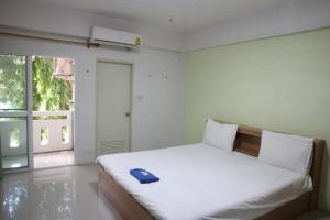 a bedroom with a bed with a blue towel on it at พีพีเพลส in Ban Lak Roi