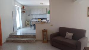 a living room with a couch and a kitchen at Casa vacanze Sisters in Vatolla