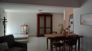 a living room with a wooden table and chairs at Casa vacanze Sisters in Vatolla