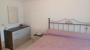 a bedroom with a large bed and a dresser at Casa vacanze Sisters in Vatolla +1 photo