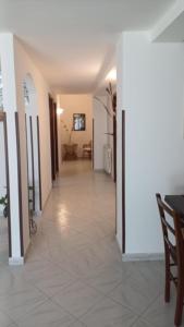 a hallway of a house with white walls and tile floors at Casa vacanze Sisters in Vatolla