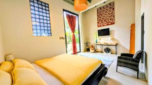 a bedroom with a bed and a tv and a window at Cargo Remote Mui Ne in Phan Thiet