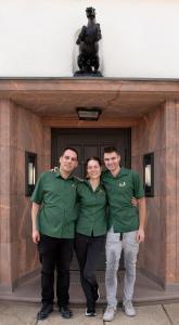 three people posing for a picture in front of a building at Hotel Roß in Zwönitz