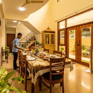 a man standing in a kitchen with a dining table at Theap Hospitality Enterprises in Noida