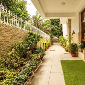 a courtyard with plants and a stone wall at Theap Hospitality Enterprises in Noida
